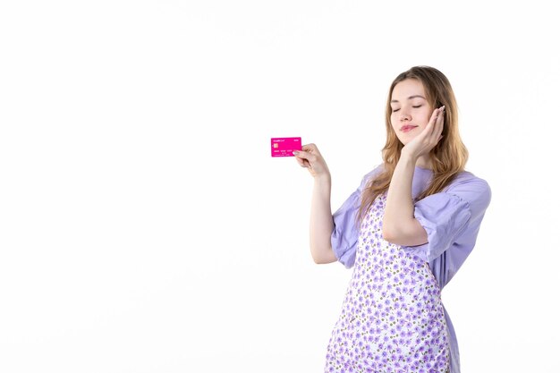 front view young female holding pink bank card on a white background flower garden gardener plant grass woman color