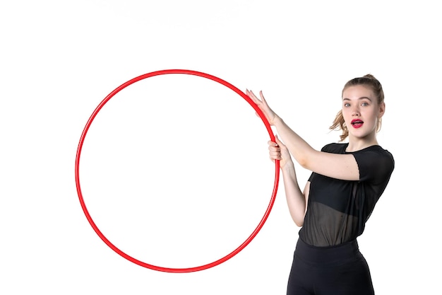 front view young female holding red hula hoop on the white background color yoga body lifestyle health athlete circus sport woman