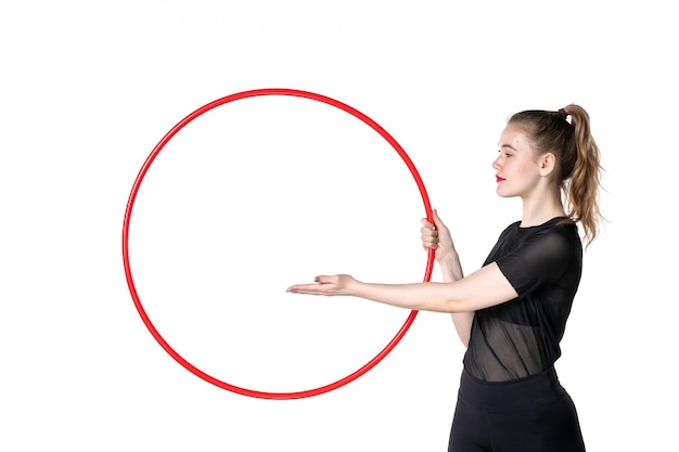 front view young female holding red hula hoop on white background yoga body color lifestyle health sport athlete woman