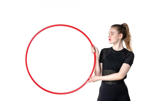 front view young female holding red hula hoop on white desk color yoga body lifestyle athlete circus sport woman health