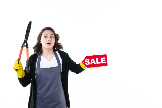 front view young female holding red sale writing and secateurs on white background garden flower job color nature grass gardener tree