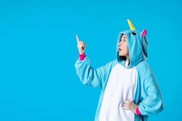 front view young female in kigurumi for pajama party on blue background rest sleep late fun game friends bed dream color