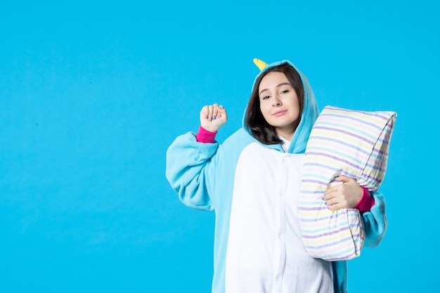 front view young female in kigurumi for pajama party hugging pillow on blue background cartoon dream sleep late friends yawn game night fun color anime