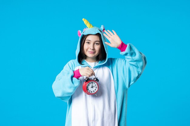 front view young female in pajama party holding clocks on blue background late dream rest bed nightmare fun sleep night game woman