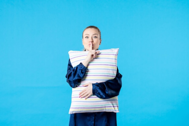 front view young female in pajamas holding pillow on blue background color sleep nightmare party dream yawn night tired rest woman