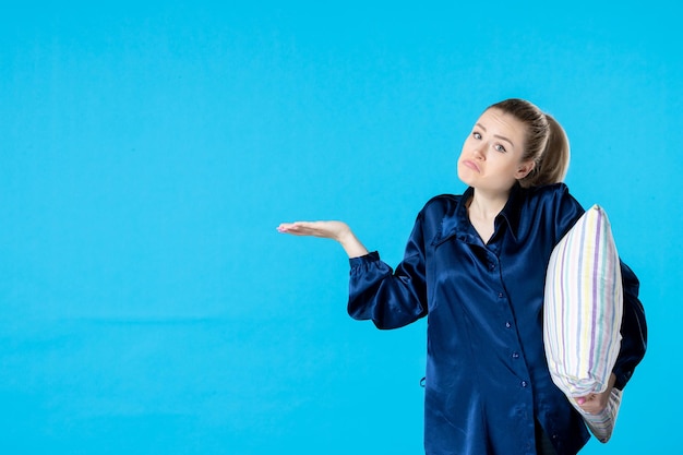 Photo front view young female in pajamas holding pillow on blue background nightmare party color dream yawn sleep night rest woman bed