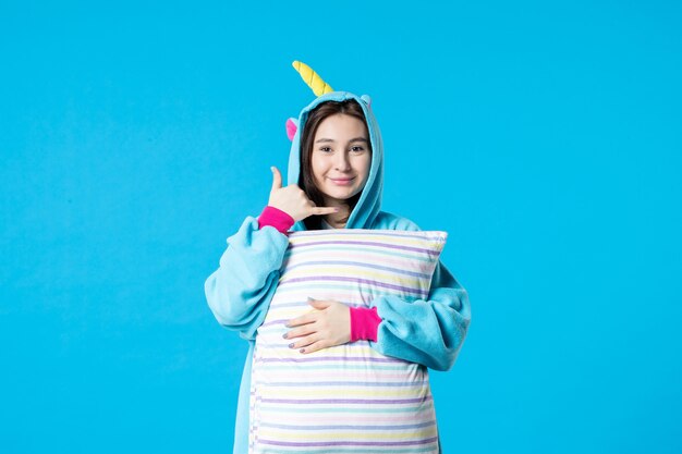 front view young female in pajamas for pajama party holding pillow on light-blue background bed night rest sleep nightmare late woman fun dream game sea