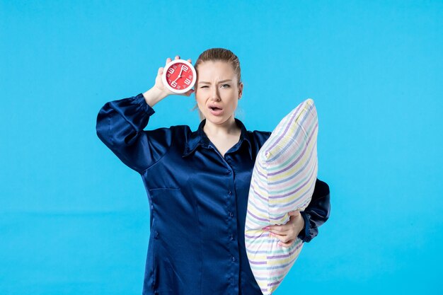 front view young female in pajamas with clock and pillow on blue background night party rest sleep tired late woman dream bed nightmare