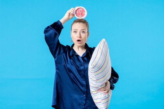 front view young female in pajamas with clock and pillow on blue background night party rest sleep tired woman bed nightmare late