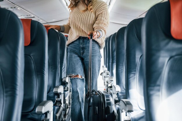 Foto vista frontale il giovane passeggero femminile in abiti casual è nell'aereo