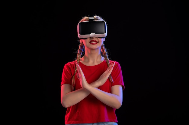 Front view of young female playing vr on dark wall