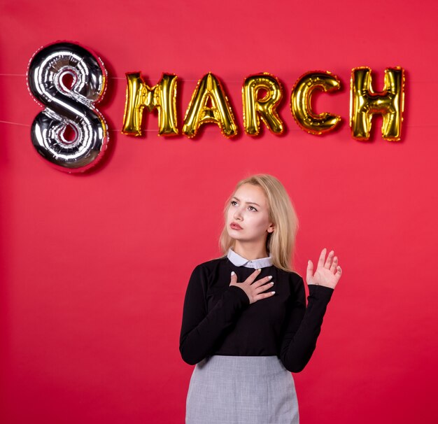 front view young female posing with march decoration on red background salon love feminine luxurious holiday equality womans day passion