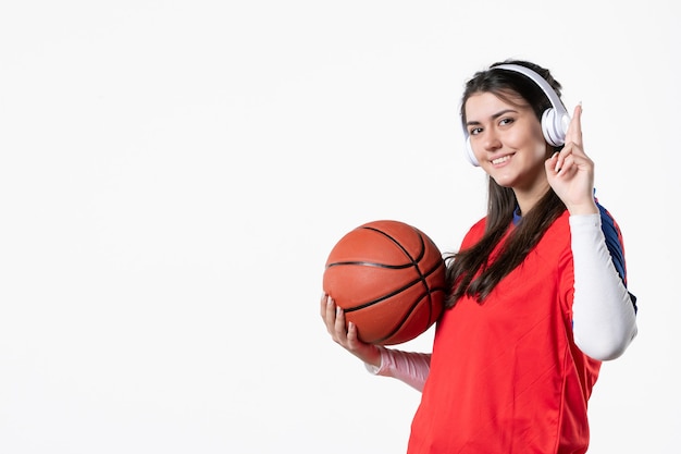 Front view young female in sport clothes with basketball