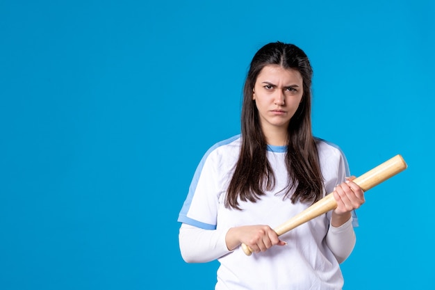 Front view young female with baseball bat on blue wall