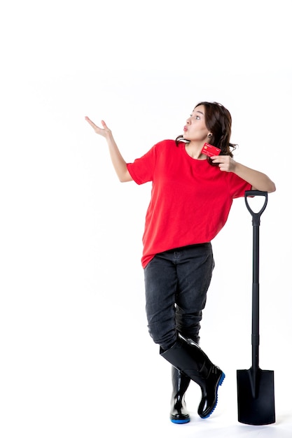 front view young female with black shovel and bank card on white background woman work soil job night color digging money