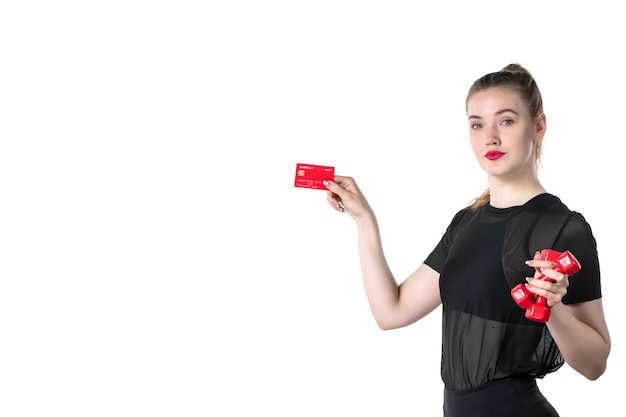 front view young female with dumbbells and bank card in her hands on white background gym money athlete sport lifestyle health body