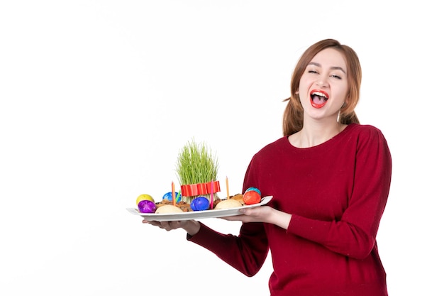 正面図白い背景の上のセメニとノウルーズのお菓子とホンカと若い女性コンセプトパフォーマー休日民族色民族春