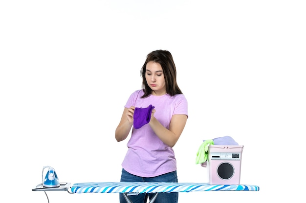 front view young housewife folding purple towel on white background housework work dry clean woman laundry emotion color