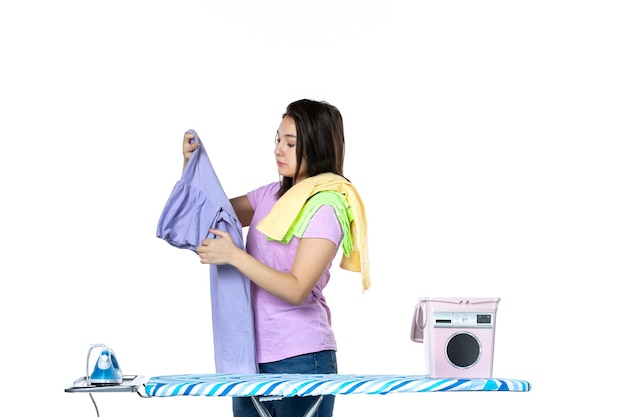 front view young housewife ironing clean clothes on ironing board on a white background dry housework laundry iron woman clean work machine