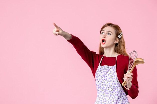 front view young housewife with spoon and whisk on pink background sweet color cooking kitchen food woman cake pie cuisine dough