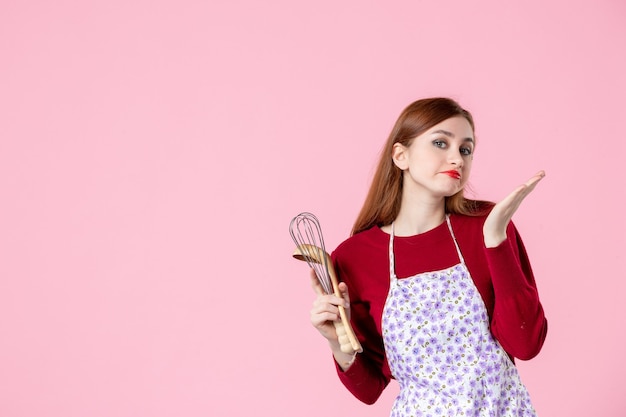 вид спереди молодая домохозяйка с ложкой и венчиком на розовом фоне сладкий цвет кухня еда торт пирог кухня готовка женщина