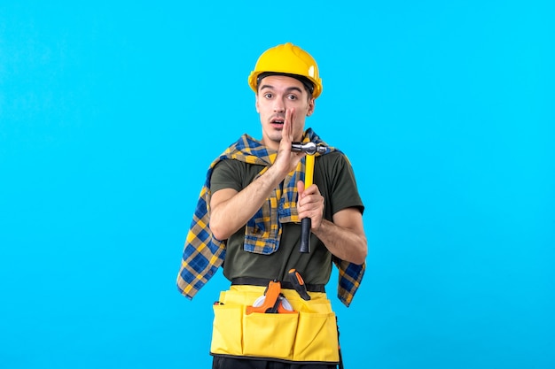 front view young male builder holding hammer on blue background worker house architecture constructor flat building