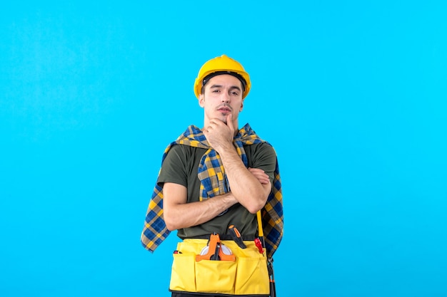 front view young male builder in yellow helmet on blue background color flat constructor architecture tool building worker