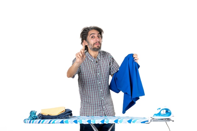 front view young male holding blue shirt on white background housework work iron man home clothes clean machine