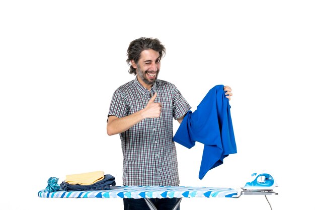 front view young male holding blue shirt on white background housework work iron man home clothes machine laundry