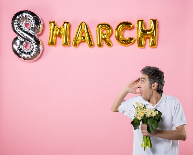 front view young male holding flowers for woman with march decorated pink background feminine party equality womens day emotion sensual glamour holidays