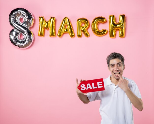 front view young male holding red sale nameplate with march decorated pink background equality present glamour party money mall sensual