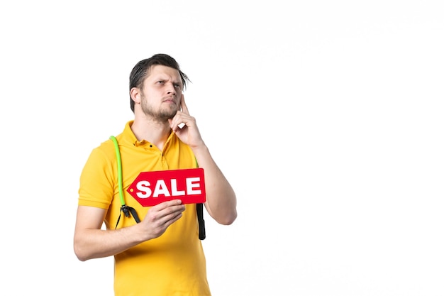 front view young male holding red sale written nameplate on white background gym job sport salesman uniform health worker shopping