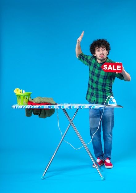 вид спереди молодой мужчина держит распродажу письмо на синем фоне человеческая стиральная машина работа по дому цвет дом чистый