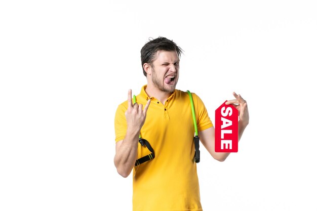 front view young male holding sale written nameplate on white background job sport human shopping salesman worker gym uniform