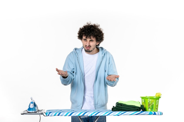 front view young male behind ironing board on a white background color man laundry housework photo cleaning iron clothes