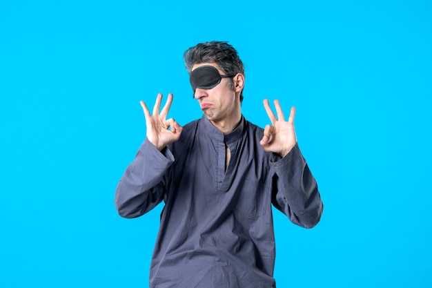 front view young male in pajamas with bandage for sleep delighted on blue background night color sleep dream nightmare bedroom dark bed