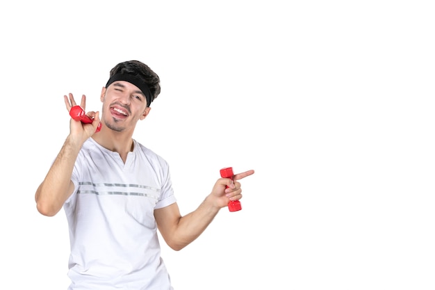 front view young male training with dumbbells on his hands on white background body fit diet health athlete human lifestyle sport yoga