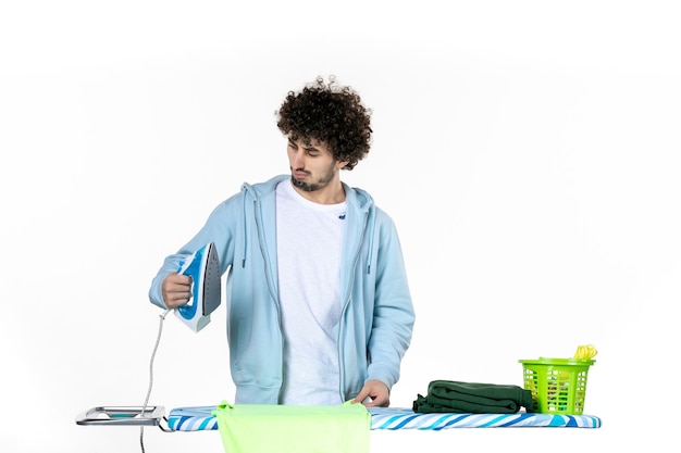 front view young male trying to iron towel on white background iron color man laundry clothes housework cleaning emotion