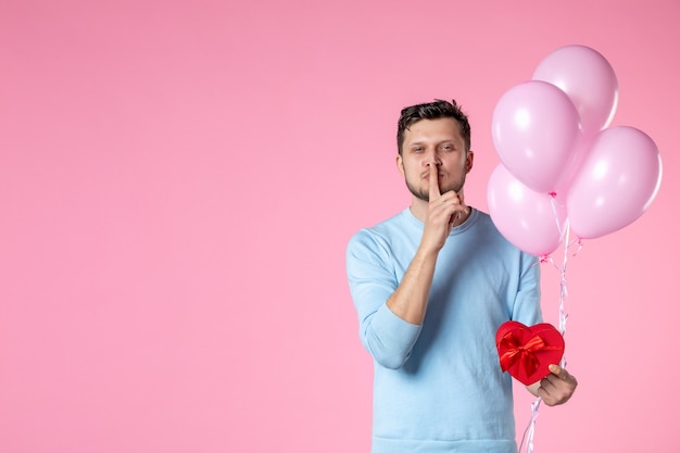 front view young male with cute pink balloons and heart shaped present on pink background love sensual equality womens day march feminine park date marriage