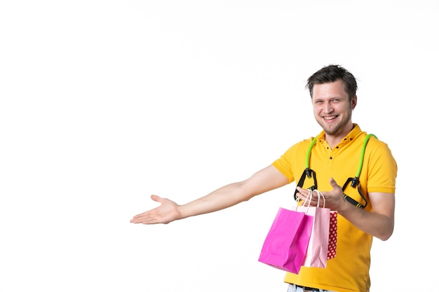 front view young male with expander holding gift packages on white background job color sport human salesman worker shopping