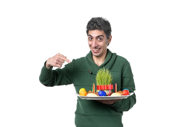 front view young man holding novruz honca with sweets and semeni on white background ethnicity performer colours horizontal concept ethnic spring