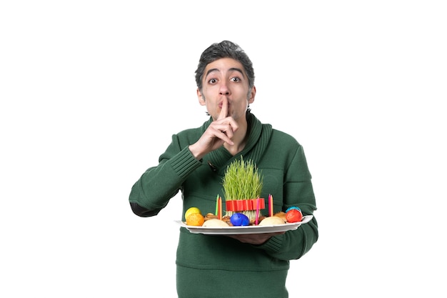 front view young man holding novruz xoncha with sweets and semeni on white background ethnicity performer colours horizontal concept ethnic