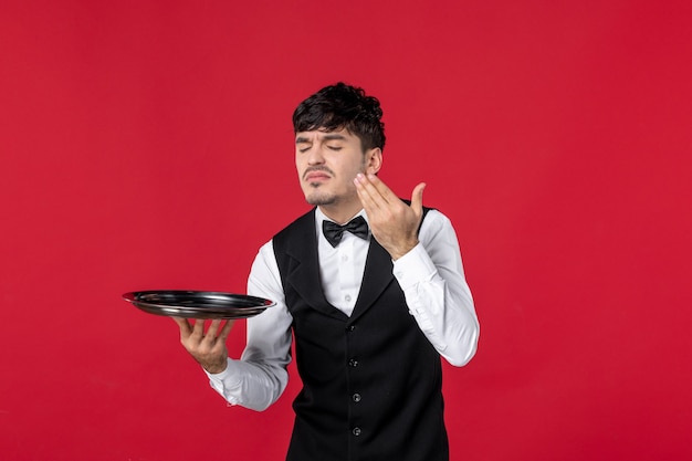 Front view of young man waiter in a uniform