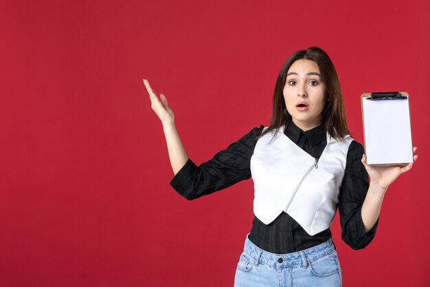 front view young pretty waitress in uniform holding file note for orders on red background work beauty woman job worker dinner evening