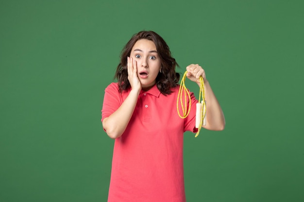 Front view young saleswoman holding skipping rope on green background sale boutique shopping worker sport health job present