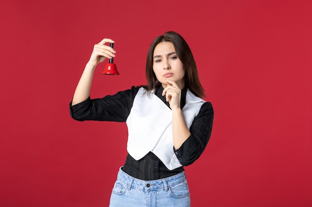 front view young waitress in uniform holding little bell on red background dinner evening work job cafe beauty color worker restaurant