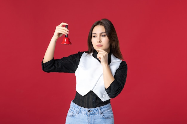 front view young waitress in uniform holding little bell on red background dinner evening work job woman beauty color worker restaurant