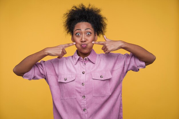 Front view of a young woman being silly while puffing her cheeks