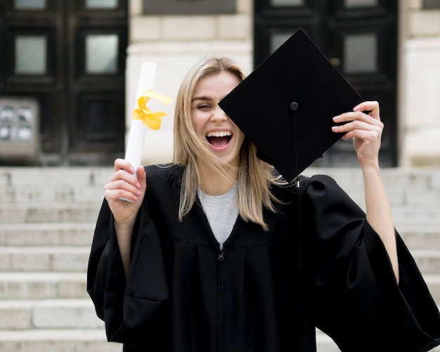 Foto giovane donna di vista frontale che celebra la sua laurea