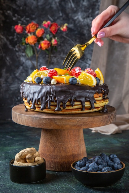 Front view yummy chocolate cake with fresh fruits on dark wall